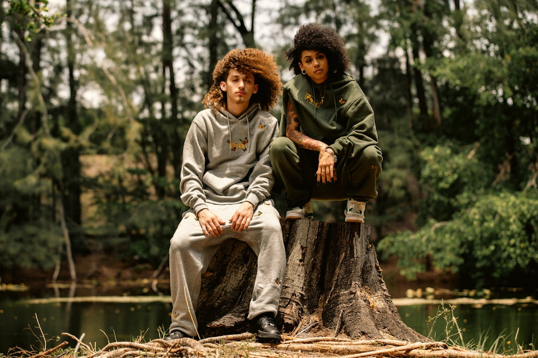 A couple of people sitting on top of a tree stump