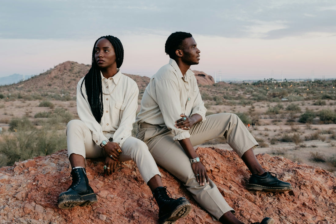 Two people sitting on a desert landscape